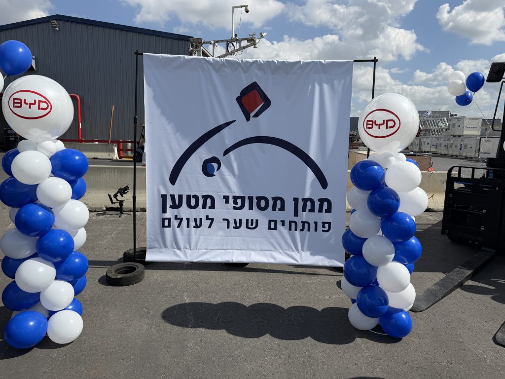 עמודי בלונים בכחול ולבן עם בלוני BYD בכניסה לאירוע של ממן מסופי מטען