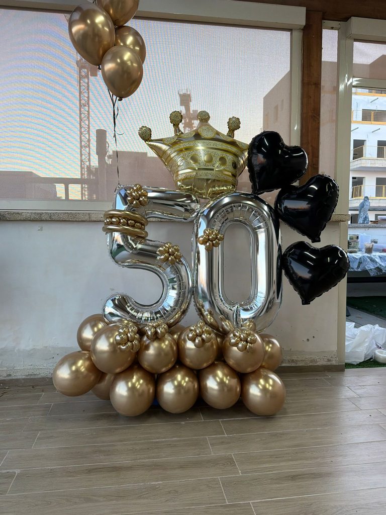 מגדל בלונים ליום הולדת 50: ספרות כסופות עם כתר זהב, לבבות שחורים ובסיס בלוני זהב
